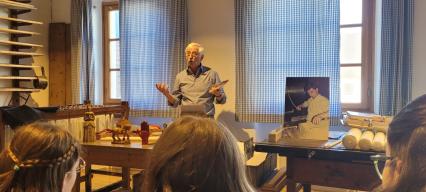 Votive auf dem Tisch. Herr Hipp hält traditionelle Honigzelten hoch.